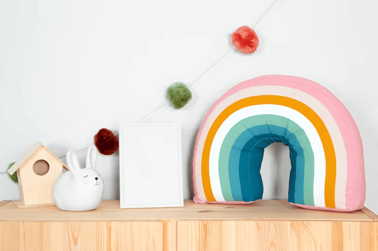 a white picture frame and a rainbow pillow on a shelf